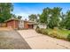 This property showcases a well-maintained lawn, mature trees, and a long driveway leading to the house at 8051 S Kendall Blvd, Littleton, CO 80128