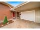 Attached garage and front entrance featuring a red door, small garden, and a well-maintained exterior at 8051 S Kendall Blvd, Littleton, CO 80128