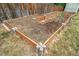 Elevated wooden gardening beds accented with modern grey block design, located within a fenced backyard at 8051 S Kendall Blvd, Littleton, CO 80128