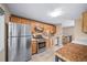 Kitchen with stainless steel appliances and modern backsplash, open to staircase at 8051 S Kendall Blvd, Littleton, CO 80128