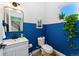 Bathroom featuring blue lower walls, a white vanity with sink and a window overlooking plants at 550 S Raleigh St, Denver, CO 80219
