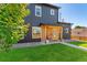 Modern two-story home featuring stylish black siding and a neat front lawn at 550 S Raleigh St, Denver, CO 80219
