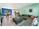 Open-concept living space with a stylish green sofa, open kitchen, and dining area at 550 S Raleigh St, Denver, CO 80219