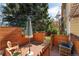 Charming backyard featuring a wood fence, brick patio, mature tree, and cozy outdoor seating at 938 W Peakview Cir, Littleton, CO 80120