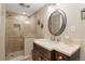Attractive bathroom with a seamless glass shower, dark wood vanity, and earth-tone finishes at 938 W Peakview Cir, Littleton, CO 80120