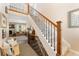 Inviting home showcasing a staircase with wooden railing and iron balusters leading to a spacious living area at 938 W Peakview Cir, Littleton, CO 80120