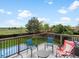 Outdoor deck with black metal railing, chairs, a table, and a view of the grass yard and trees at 10536 Garrison St, Westminster, CO 80021