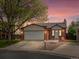 Charming single Gathering home with brick, two car garage, landscaped front yard and walkway with colorful sunset at 10536 Garrison St, Westminster, CO 80021