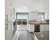 Bright kitchen boasts stainless appliances, grey countertops, white cabinetry, and access to the wood deck at 10536 Garrison St, Westminster, CO 80021
