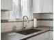 Updated kitchen features stainless steel sink with modern faucet, and white subway tile backsplash at 10536 Garrison St, Westminster, CO 80021