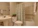 Bathroom featuring tan tile, a toilet with plants on top, and a patterned shower curtain at 19326 E Greenwood Pl, Aurora, CO 80013