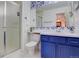 Bathroom featuring a blue vanity, tiled backsplash, and a glass-enclosed shower stall at 19326 E Greenwood Pl, Aurora, CO 80013