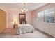 Cozy bedroom with soft pink walls, a comfortable bed, and a chandelier for ambient lighting at 19326 E Greenwood Pl, Aurora, CO 80013