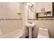 Updated bathroom with pedestal sink and tiled shower-tub at 6900 S Clermont St, Centennial, CO 80122