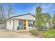 Charming home with a beautifully painted exterior, a vibrant turquoise door, and manicured landscaping at 6900 S Clermont St, Centennial, CO 80122