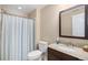 Bathroom with a shower/tub combo, vanity with granite top and dark wood cabinet, and a neutral striped shower curtain at 2558 Northview Pl, Castle Rock, CO 80104