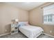 Cozy bedroom with a white bed frame, striped bedding, a side table and a window with blinds at 2558 Northview Pl, Castle Rock, CO 80104