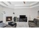 Cozy living room with a fireplace, tray ceiling, and plush gray carpeting at 2558 Northview Pl, Castle Rock, CO 80104