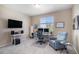 Well-lit office space with a desk, chair, shelving unit, tv and a comfortable armchair on neutral carpet at 2558 Northview Pl, Castle Rock, CO 80104