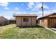 Backyard featuring a charming shed with a brown shingle roof, adjacent to a matching utility building with secure windows at 111 S Perry St, Denver, CO 80219