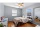 Comfortable bedroom with light blue walls, hardwood floors, and a ceiling fan at 111 S Perry St, Denver, CO 80219