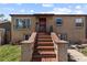 Inviting brick home featuring a prominent entrance with brick steps, a red door, and manicured landscaping at 111 S Perry St, Denver, CO 80219