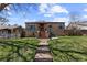Charming brick home featuring a well-manicured lawn, classic brick steps, and inviting curb appeal at 111 S Perry St, Denver, CO 80219