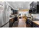Open kitchen with black appliances, light wood floors, and seamless access to the living room at 111 S Perry St, Denver, CO 80219