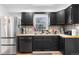 Bright kitchen featuring black cabinets, stainless steel appliances, and a view of the outdoors at 111 S Perry St, Denver, CO 80219