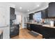 Traditional kitchen featuring black cabinets, stainless steel appliances, and wood-look floors at 111 S Perry St, Denver, CO 80219