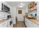 Modern kitchen featuring white cabinets, wood countertops, and stainless steel appliances at 111 S Perry St, Denver, CO 80219