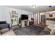 Cozy living area with a large TV, rustic shelving, a comfortable couch, and open access to other rooms at 111 S Perry St, Denver, CO 80219