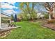 Lush backyard with mature trees, a cozy patio, and a charming picnic area, ideal for outdoor gatherings at 6712 S Leyden Ct, Centennial, CO 80112