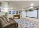 Finished basement with movie screen, projector, foosball table, and cozy couch at 6712 S Leyden Ct, Centennial, CO 80112