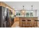 Spacious kitchen featuring stainless steel appliances, natural wood cabinetry, breakfast bar, and hardwood floors at 6712 S Leyden Ct, Centennial, CO 80112