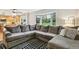 Spacious living room featuring a large sectional sofa, black and white rug, and bright natural light from the bay window at 6712 S Leyden Ct, Centennial, CO 80112
