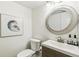 Stylish powder room with a modern vanity, a decorative mirror, and elegant wall art at 6712 S Leyden Ct, Centennial, CO 80112