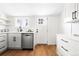 Bright kitchen featuring white cabinets, stainless steel appliances, and wood floors at 333 Quitman St, Denver, CO 80219