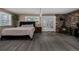 Bright bedroom with hardwood floors, stone fireplace, and access to a private balcony at 54 Zaza Ln, Evergreen, CO 80439