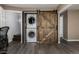 Efficient laundry area with stackable washer/dryer and sliding barn door for storage at 54 Zaza Ln, Evergreen, CO 80439
