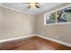 Bedroom featuring hardwood floors, natural light from the window, and wood paneling at 6508 E Euclid Pl, Centennial, CO 80111