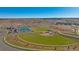 Aerial view of community amenities including baseball field, tennis courts, and parks against a scenic landscape backdrop at 14106 Red Cosmos St, Parker, CO 80134