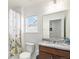 Bright bathroom featuring granite countertops, wood vanity, floral shower curtain, and a window allowing natural light at 14106 Red Cosmos St, Parker, CO 80134