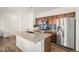 Beautiful kitchen featuring a large kitchen island, stainless steel refrigerator and wood flooring at 14106 Red Cosmos St, Parker, CO 80134