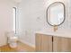 Chic powder room with patterned wallpaper, modern vanity, and stylish round mirror at 2530 Chase, Edgewater, CO 80215