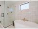 Modern bathroom showcasing a soaking tub, walk-in shower, and stylish tile work at 2530 Chase, Edgewater, CO 80215