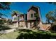 Angle view of a modern three-story townhome featuring a landscaped front yard and unique wooden details at 2530 Chase, Edgewater, CO 80215