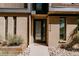 Modern townhome front entrance featuring a glass door, brick exterior, and rock landscaping at 2530 Chase, Edgewater, CO 80215