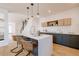 Bright kitchen showcasing a large island with bar seating, custom cabinetry, and stylish pendant lighting at 2530 Chase, Edgewater, CO 80215