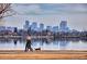 Scenic neighborhood view showcasing a lakeside walking path and city skyline at 2530 Chase, Edgewater, CO 80215
